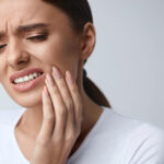 Woman Grabbing mouth in pain. Tooth pain