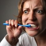 Woman Brushing her Teeth Aggressively
