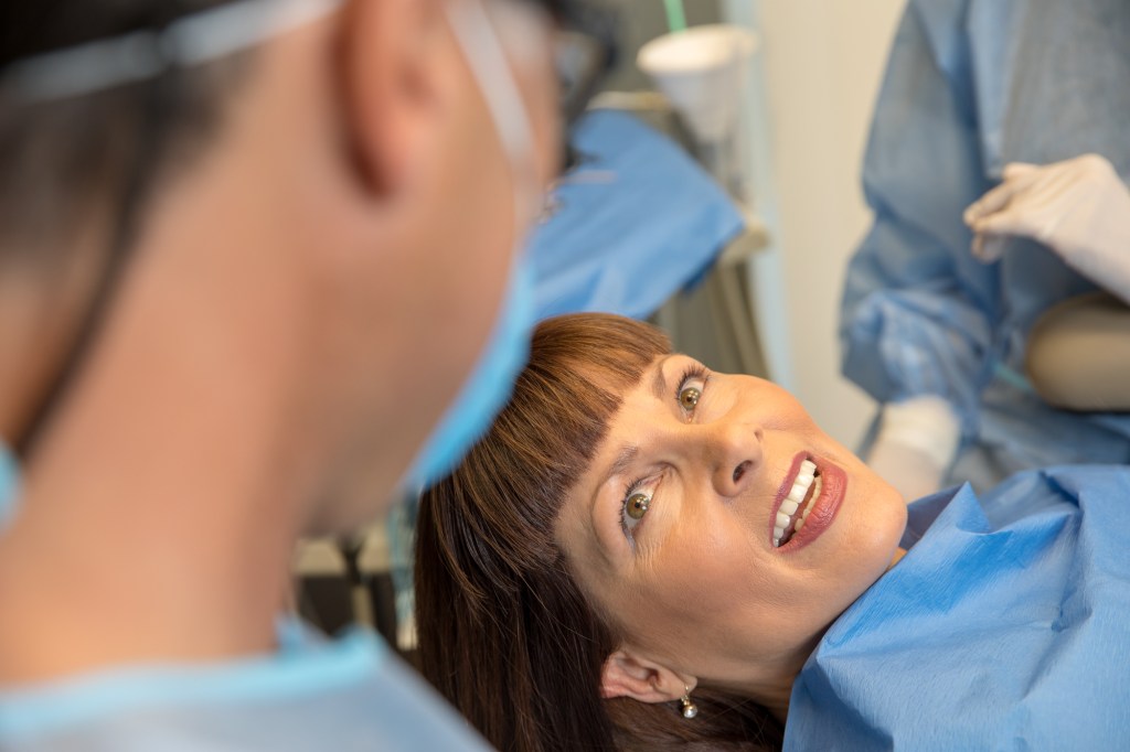 a lady showing her teeth to a dentist