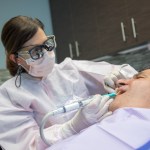 a dentist performing a periodontal service to a patient